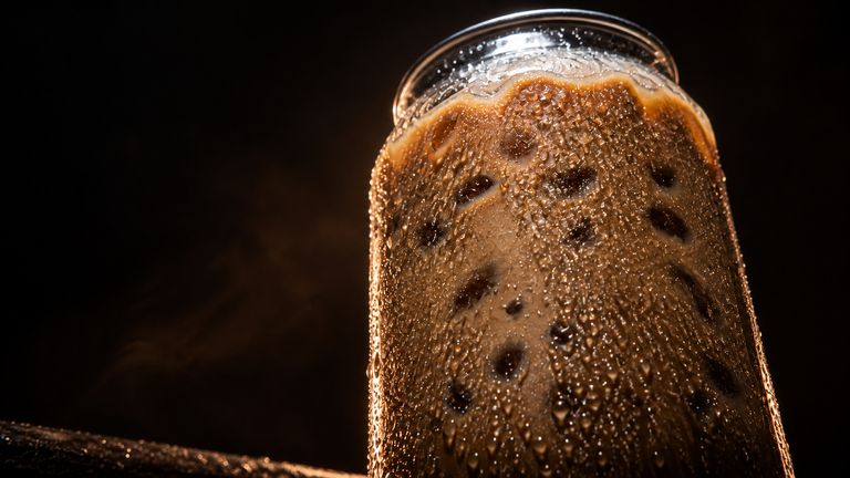 An ice-cold coffee from the trailer, the glass beaded with condensation